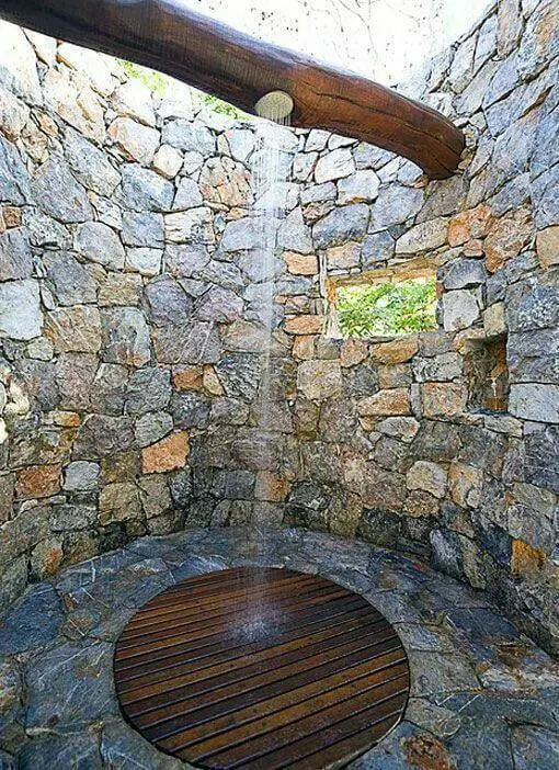 Open well bathroom with a wooden beam as shower