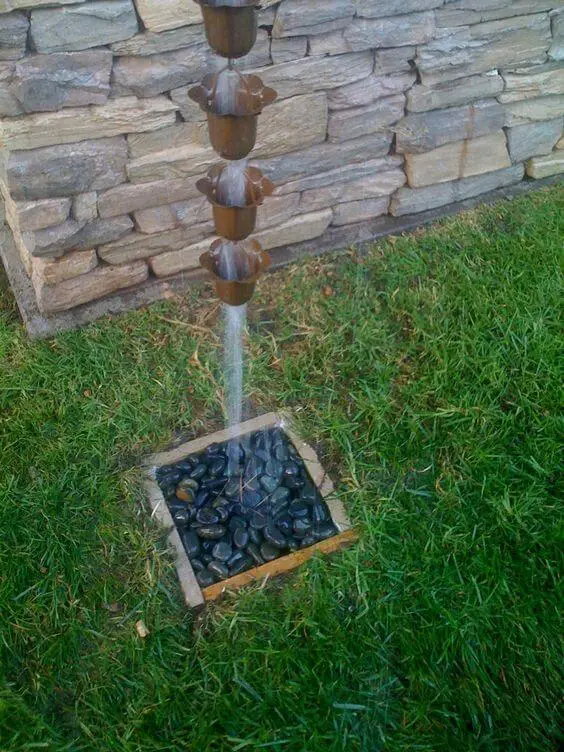 Beautiful rain water channelled into a pit filled with stones for rain water harvesting