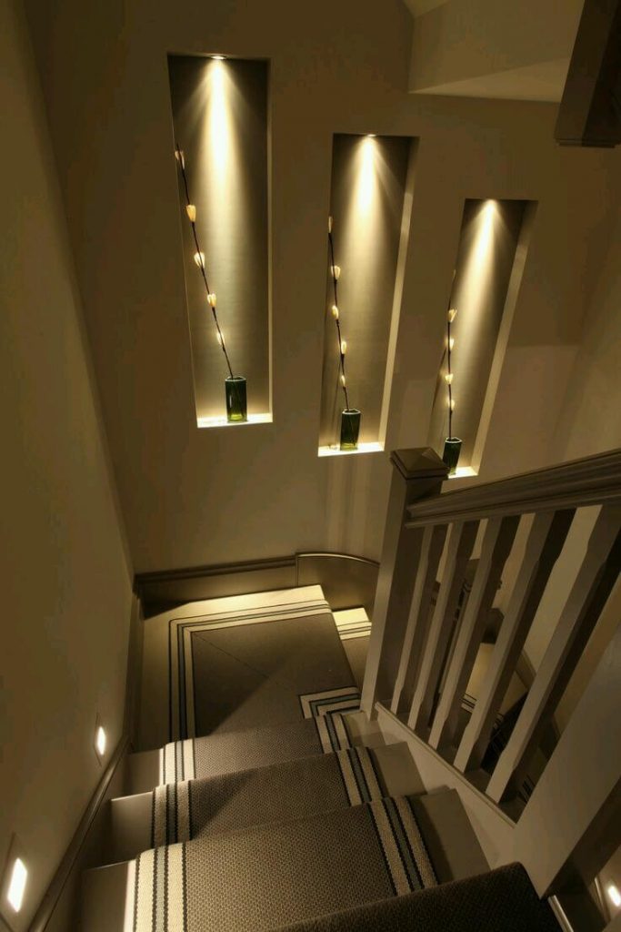 Lights highlighting sculptures on the staircase