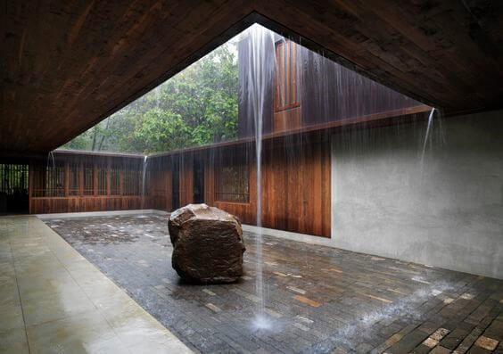 Indoor courtyard with falling water and stone in the center