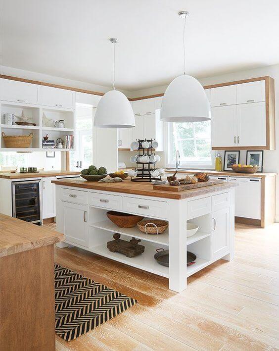 White base and wooden counter top island shaped kitchen with white light fixtures