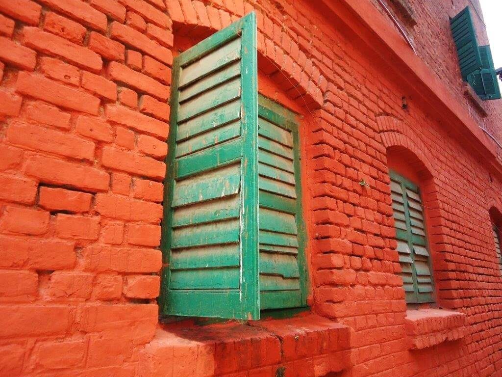 Green fenestrations windows embeded in unfinished brick look walls