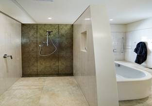Dividing shower area and bathtub area in a bathroom with a solid wall partition