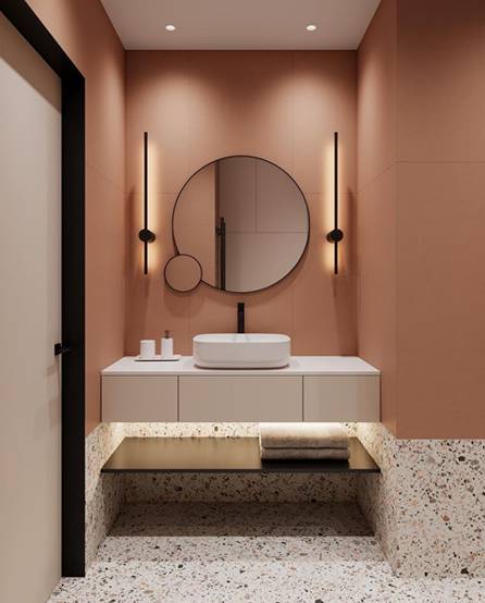 Round mirror placed above wash basin in copper coloured bathroom