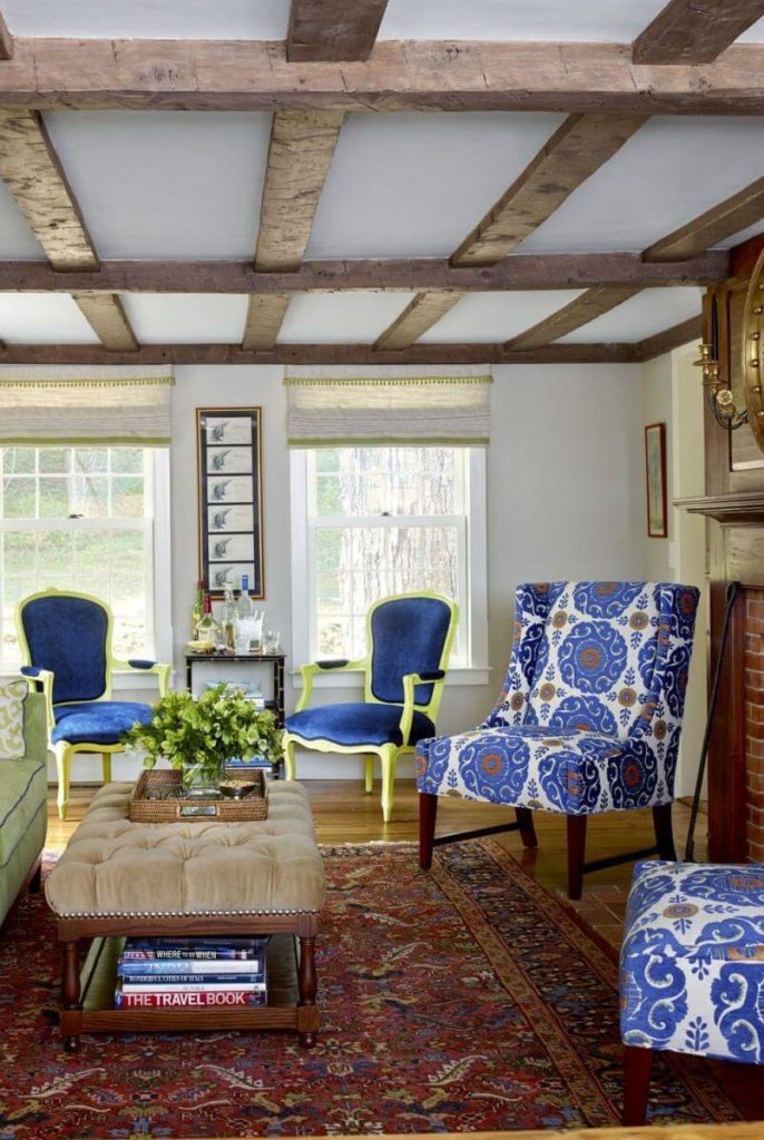 Exposed wooden beams and bright colored sofa and chairs