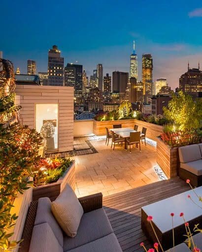 well lit roof top with garden and dining table