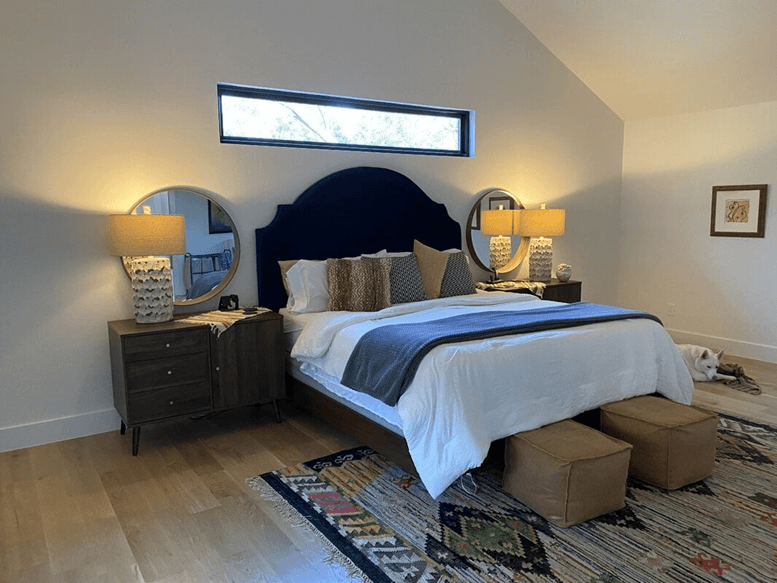 A small slit window above the headboard of the bed for natural lighting