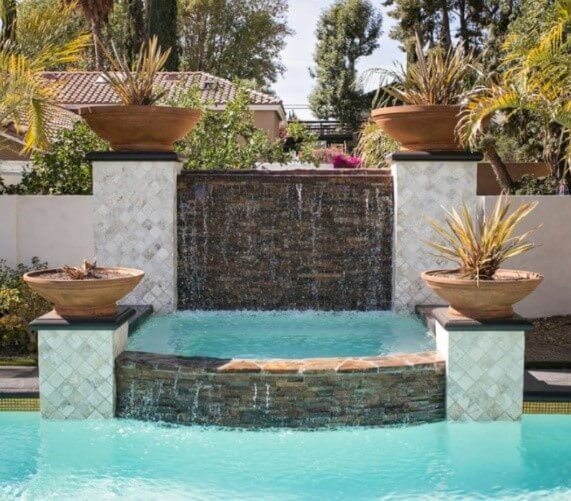 Artificial waterfall along poolside made from natural stacked stones