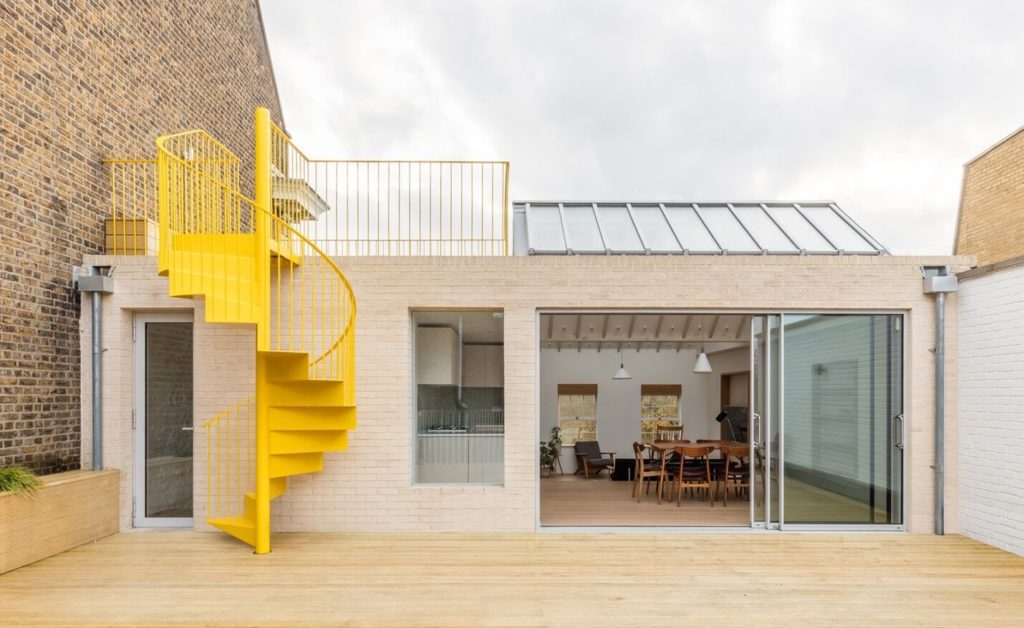 A bright yellow color painted spiral staircase to access from terrace to roof top