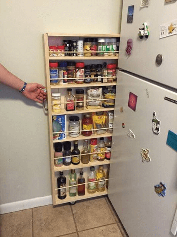 Pullout drawer beside the fridge for storing bottles and spices