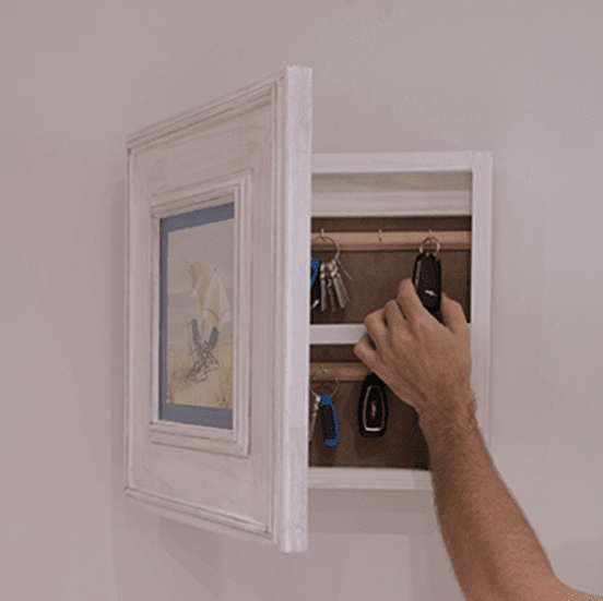 key storage hidden behind photo frame in compact homes