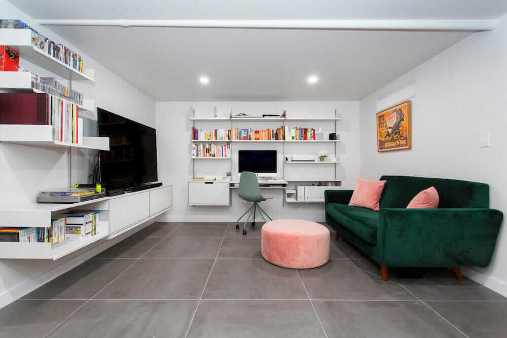 A second living room created inside a basement with sofa tv unit and work table