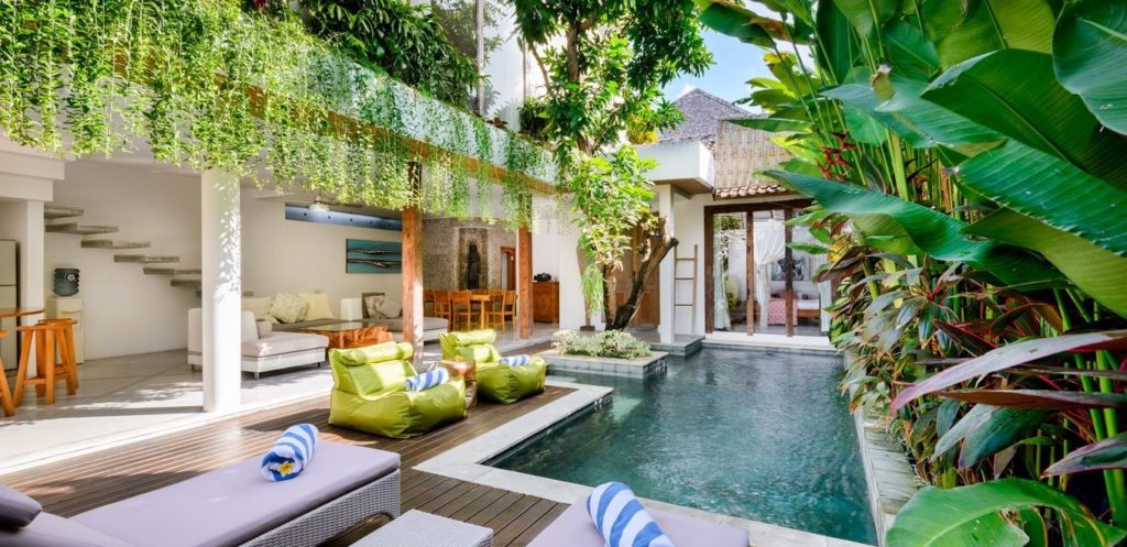Tropical decor view with swimming pool and sitting area with furniture