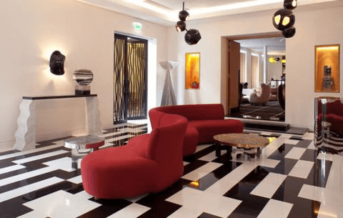 living room area with red sofa and black and white floor design